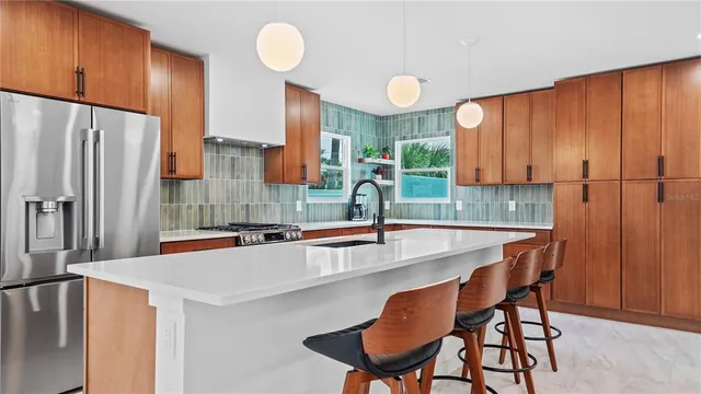 a kitchen with stainless steel appliances granite countertop a sink and a refrigerator