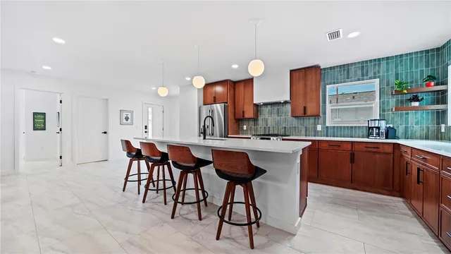 a kitchen with stainless steel appliances granite countertop a stove a sink and a microwave