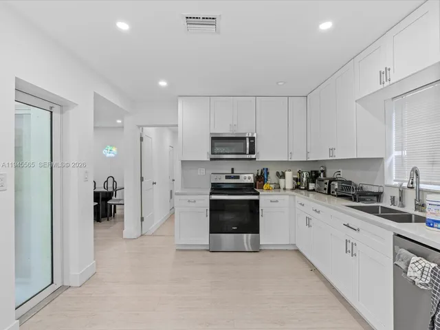 a kitchen with stainless steel appliances granite countertop a refrigerator and a stove top oven