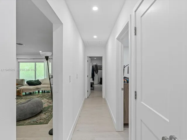 a view of a hallway and a livingroom with furniture