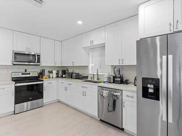 a kitchen with stainless steel appliances granite countertop a stove a refrigerator and a sink