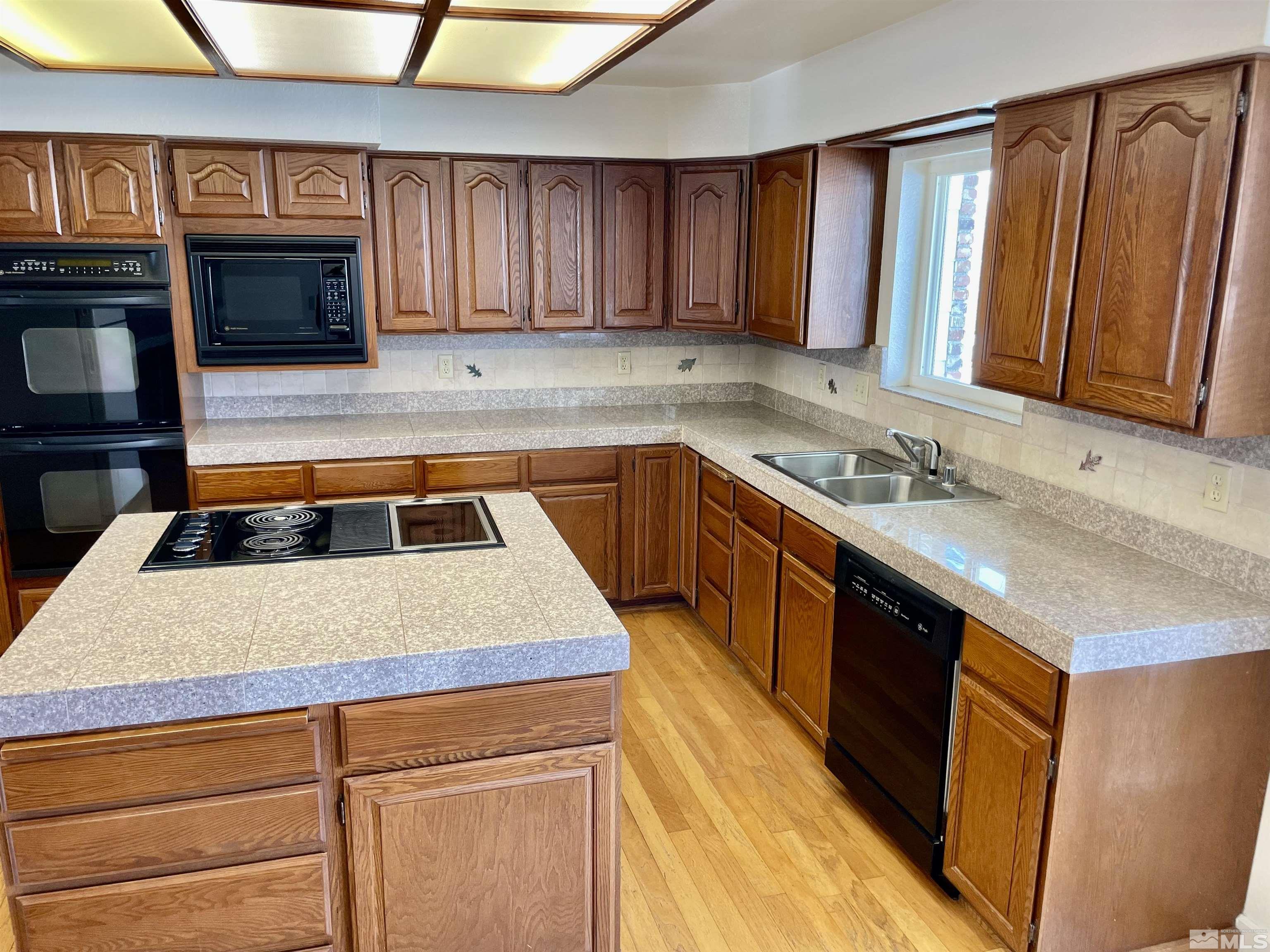 155 Cedar Lane Reno, NV 89521 - Photo 12 of 30 a kitchen with stainless steel appliances granite countertop a sink a stove and a microwave oven with cabinets