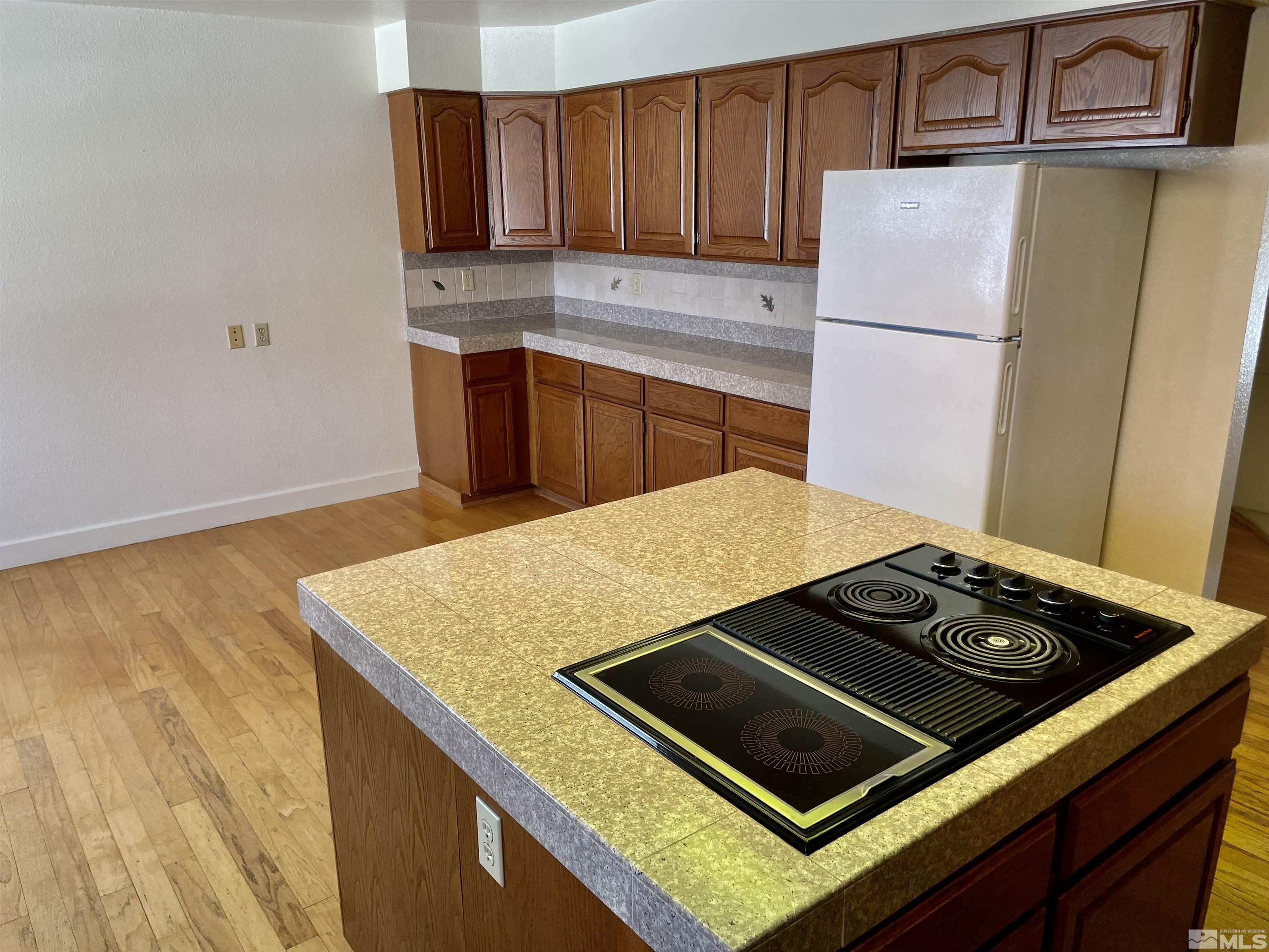 155 Cedar Lane Reno, NV 89521 - Photo 13 of 30 a kitchen with granite countertop a stove and a refrigerator