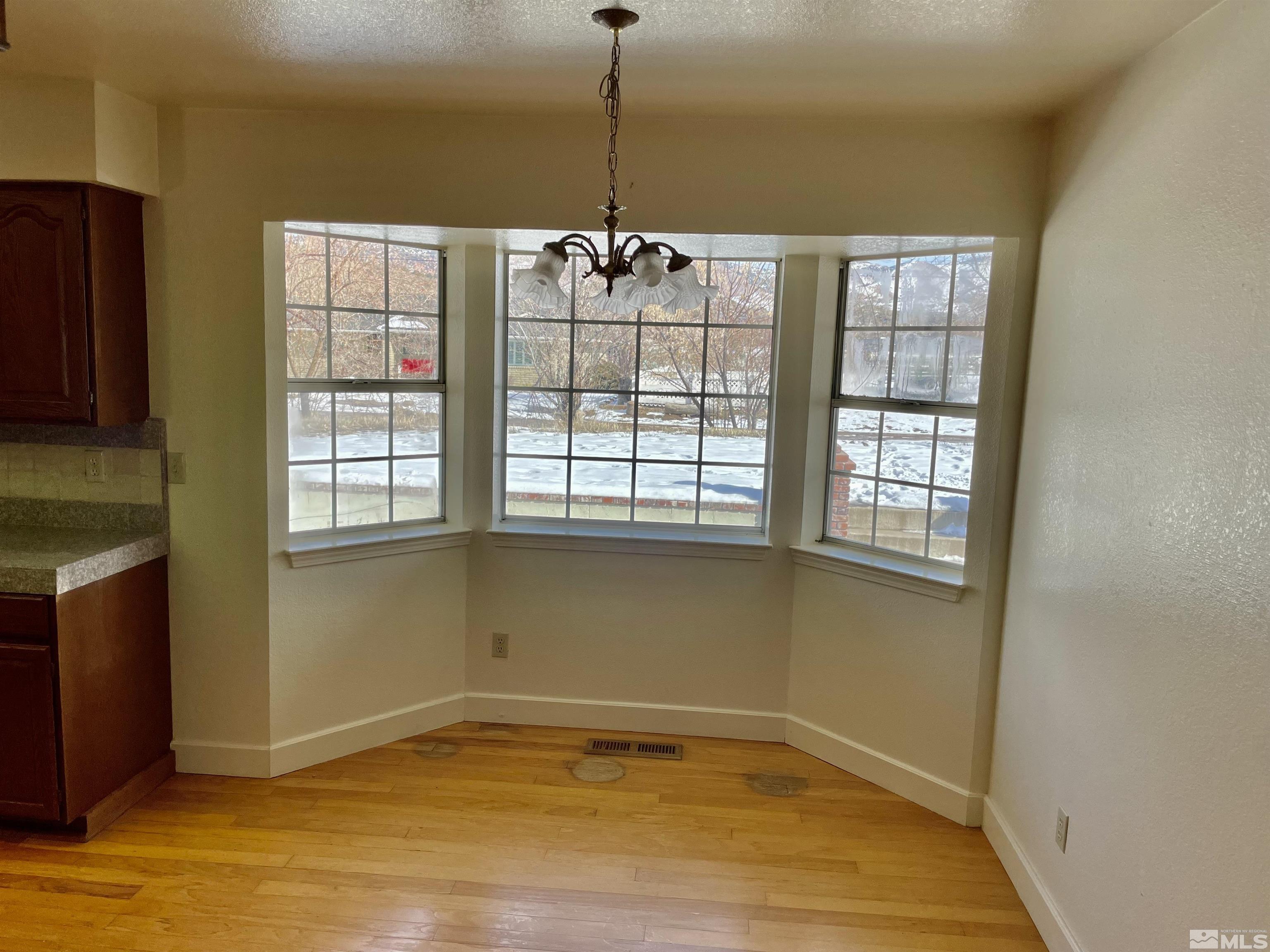 155 Cedar Lane Reno, NV 89521 - Photo 14 of 30 a view of an empty room with window and wooden floor