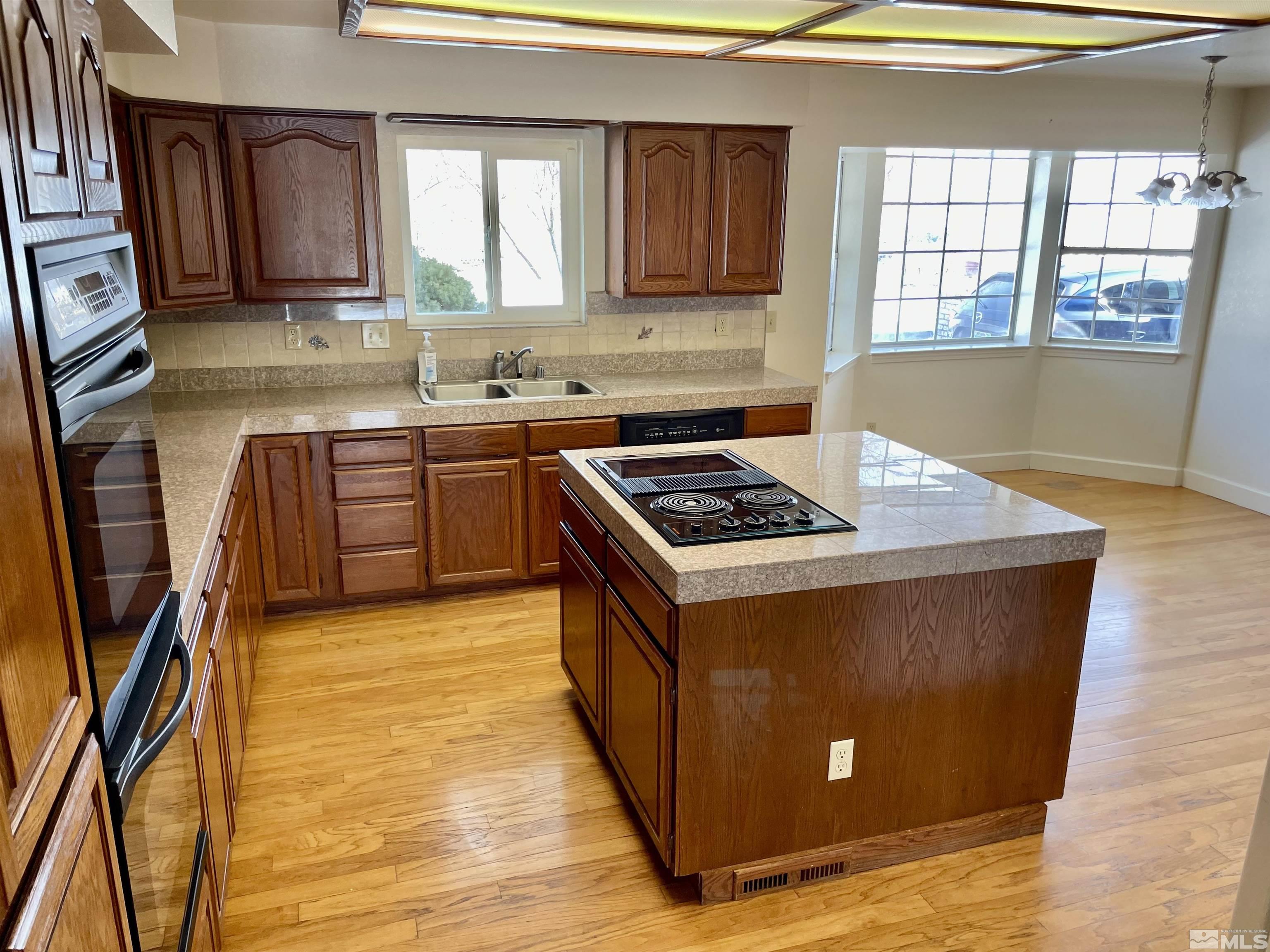 155 Cedar Lane Reno, NV 89521 - Photo 9 of 30 a kitchen with granite countertop a stove a sink dishwasher and a microwave oven with wooden cabinets