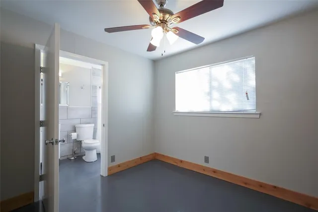 a view of a kitchen with a refrigerator a ceiling fan and wooden floor