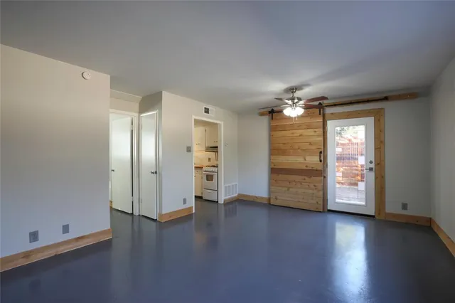an empty room with wooden floor and window