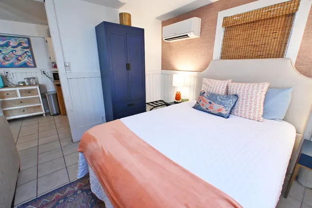 a bedroom with a bed a mirror and clock on the wall