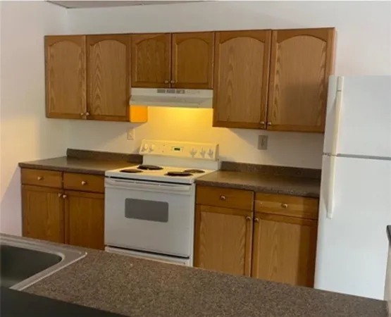 a kitchen with granite countertop cabinets stainless steel appliances and wooden cabinets