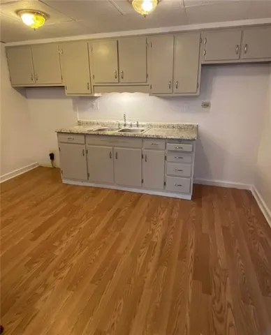 a kitchen with granite countertop a sink and cabinets