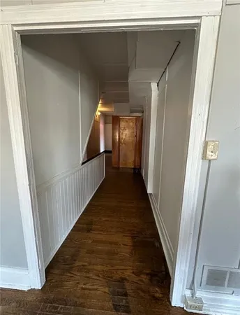 a view of a hallway with wooden floor and staircase
