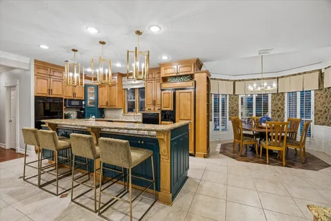 a dining hall with stainless steel appliances a dining table and chairs