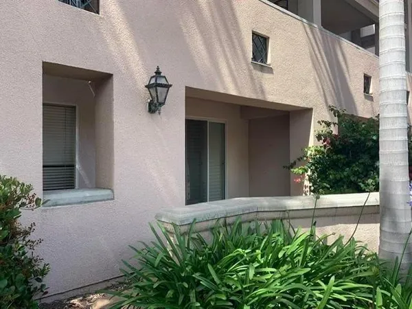a view of a house with a small yard and potted plants