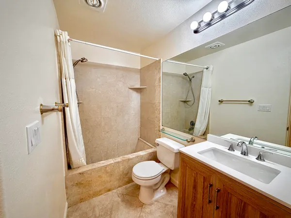 a bathroom with a sink a toilet and shower