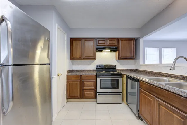 a kitchen with stainless steel appliances granite countertop a refrigerator and a sink