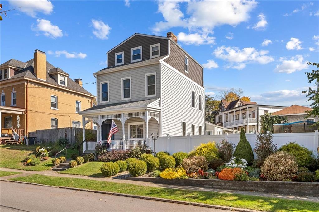 a front view of a house with a yard outdoor seating and covered with potted plants