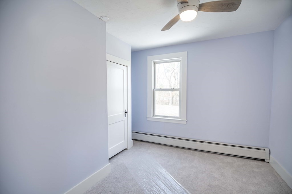 50 Newfields Road, Unit D Exeter, NH 03833 - Photo 24 of 36 an empty room with chandelier fan and windows