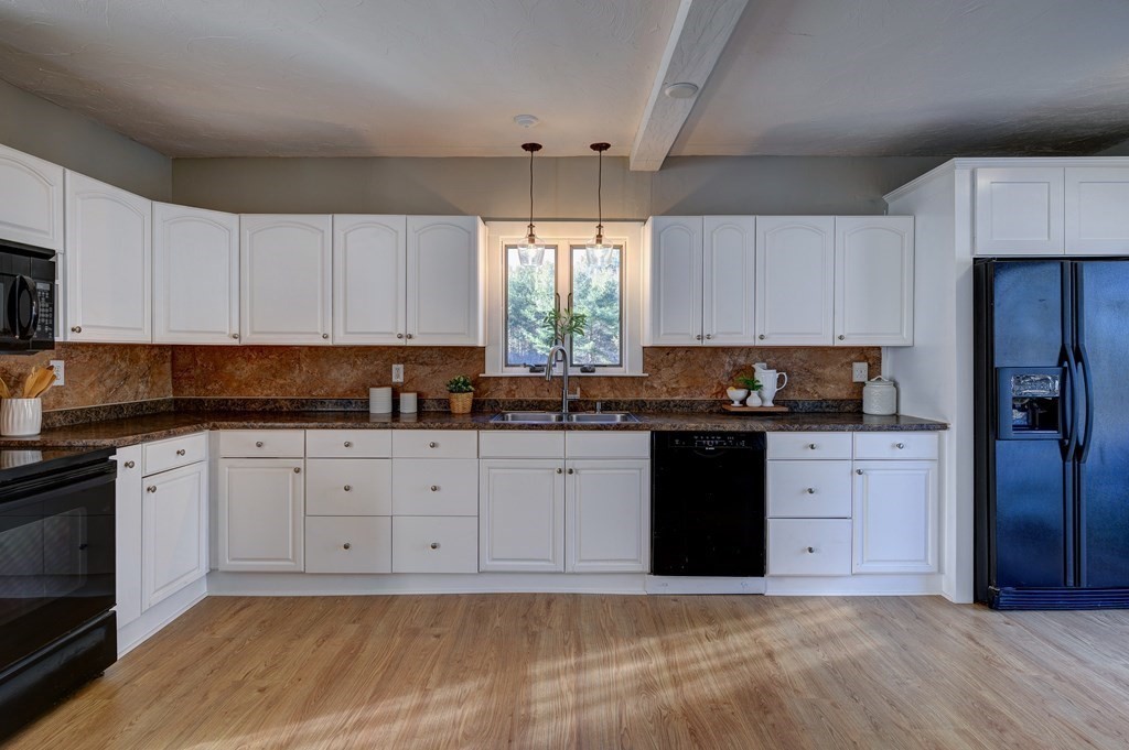 50 Newfields Road, Unit D Exeter, NH 03833 - Photo 6 of 36 a kitchen with granite countertop a stove a sink and a refrigerator