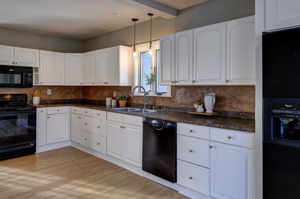50 Newfields Road, Unit D Exeter, NH 03833 - Photo 7 of 36 a kitchen with granite countertop white cabinets and stainless steel appliances