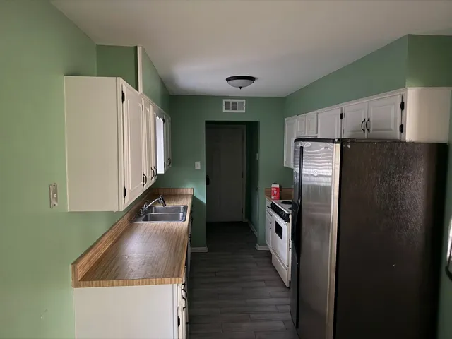 a kitchen with stainless steel appliances granite countertop a refrigerator and a sink