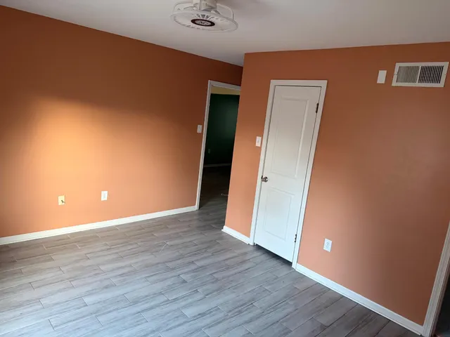 a view of an empty room with wooden floor