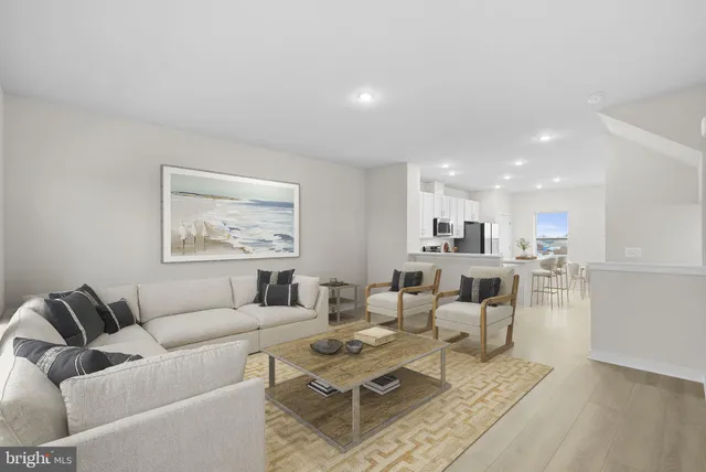 a living room with furniture and a view of kitchen
