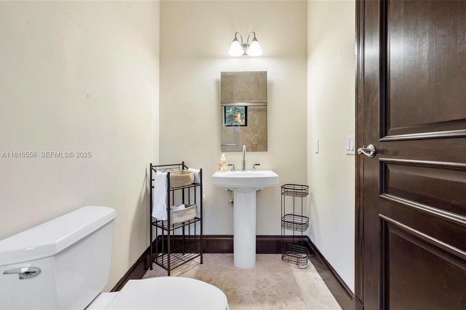 18825 North Bay Road Sunny Isles Beach, FL 33160 - Photo 36 of 62 a bathroom with a sink toilet and mirror