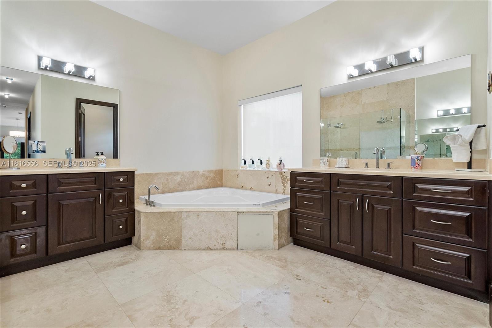 18825 North Bay Road Sunny Isles Beach, FL 33160 - Photo 42 of 62 a spacious bathroom with a granite countertop double vanity sink and a mirror