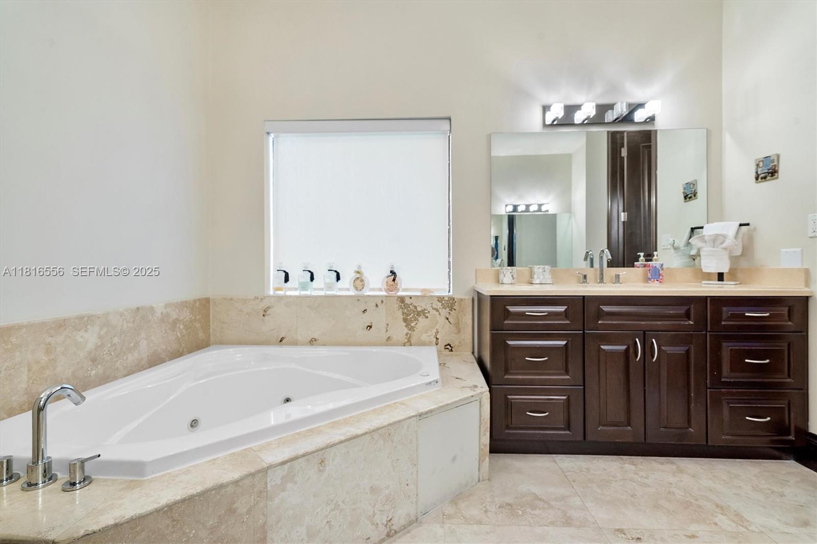 18825 North Bay Road Sunny Isles Beach, FL 33160 - Photo 45 of 62 a bathroom with a tub a double vanity sink and a mirror