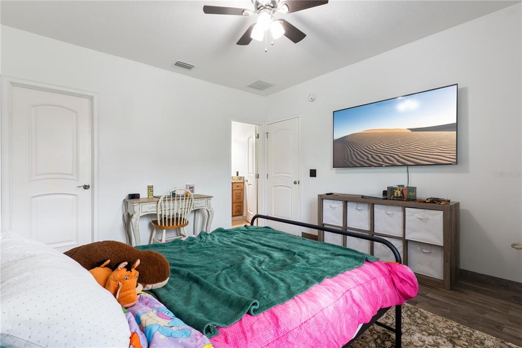 345 Cypress Isles Road Osteen, FL 32764 - Photo 24 of 41 a bedroom with a bed and a flat screen tv