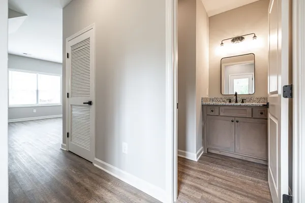 a kitchen with stainless steel appliances granite countertop a refrigerator a sink dishwasher a stove and white countertops with wooden floor