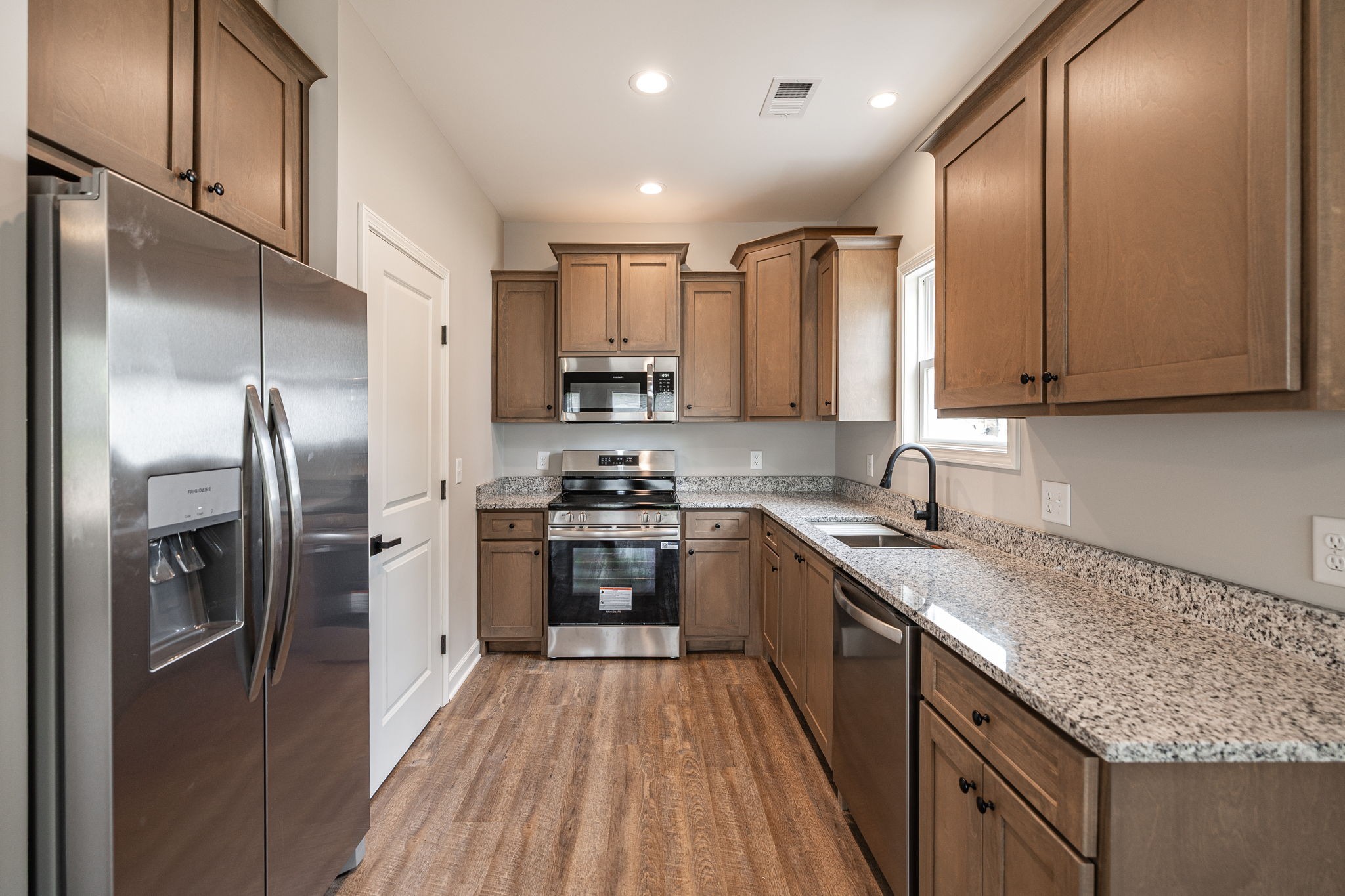 103 Portland Boulevard Portland, TN 37148 - Photo 82 of 100 a kitchen with stainless steel appliances granite countertop a refrigerator a sink dishwasher a stove and white countertops with wooden floor