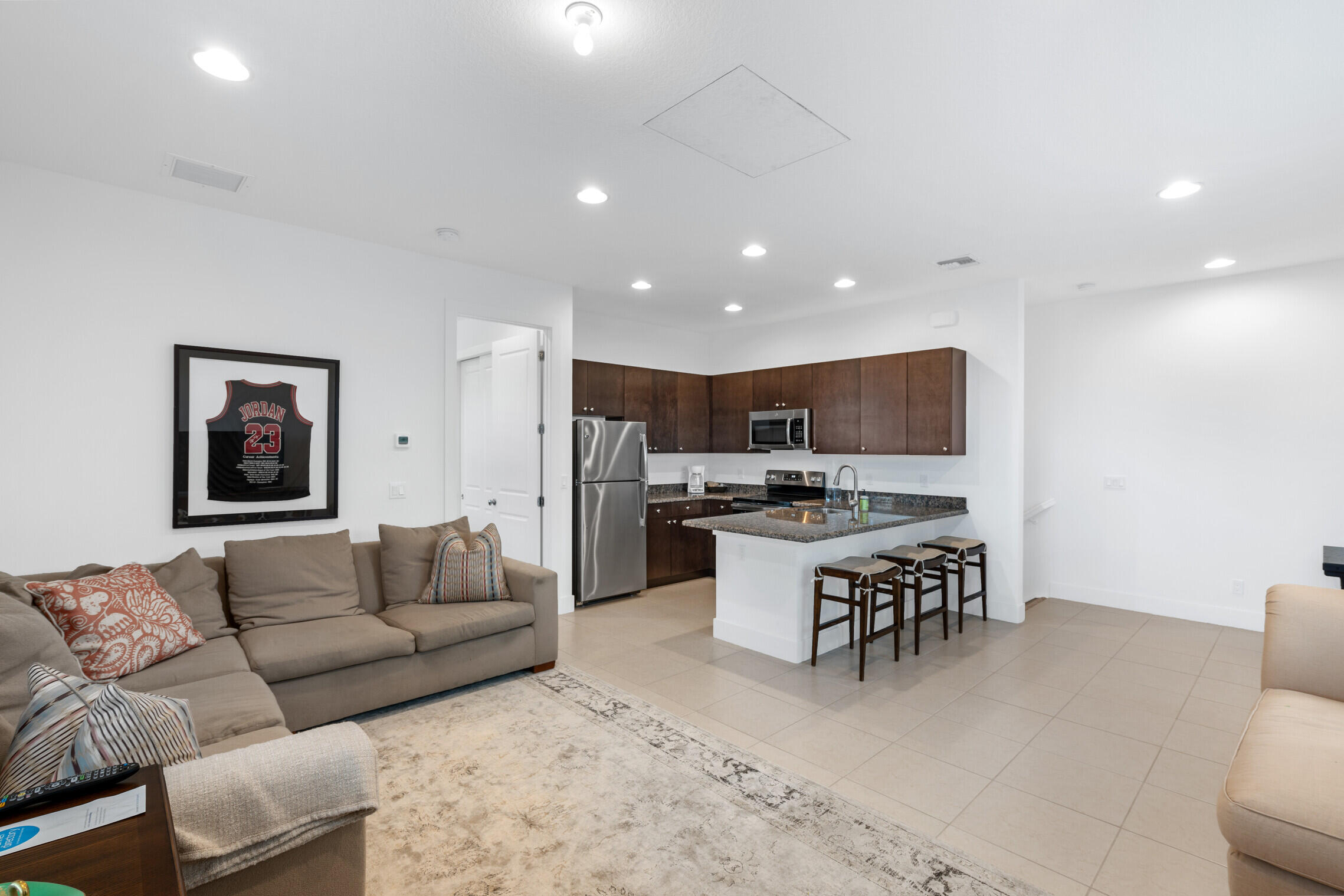 4084 Faraday Way Palm Beach Gardens, FL 33418 - Photo 33 of 43 a living room with lots of furniture and kitchen view