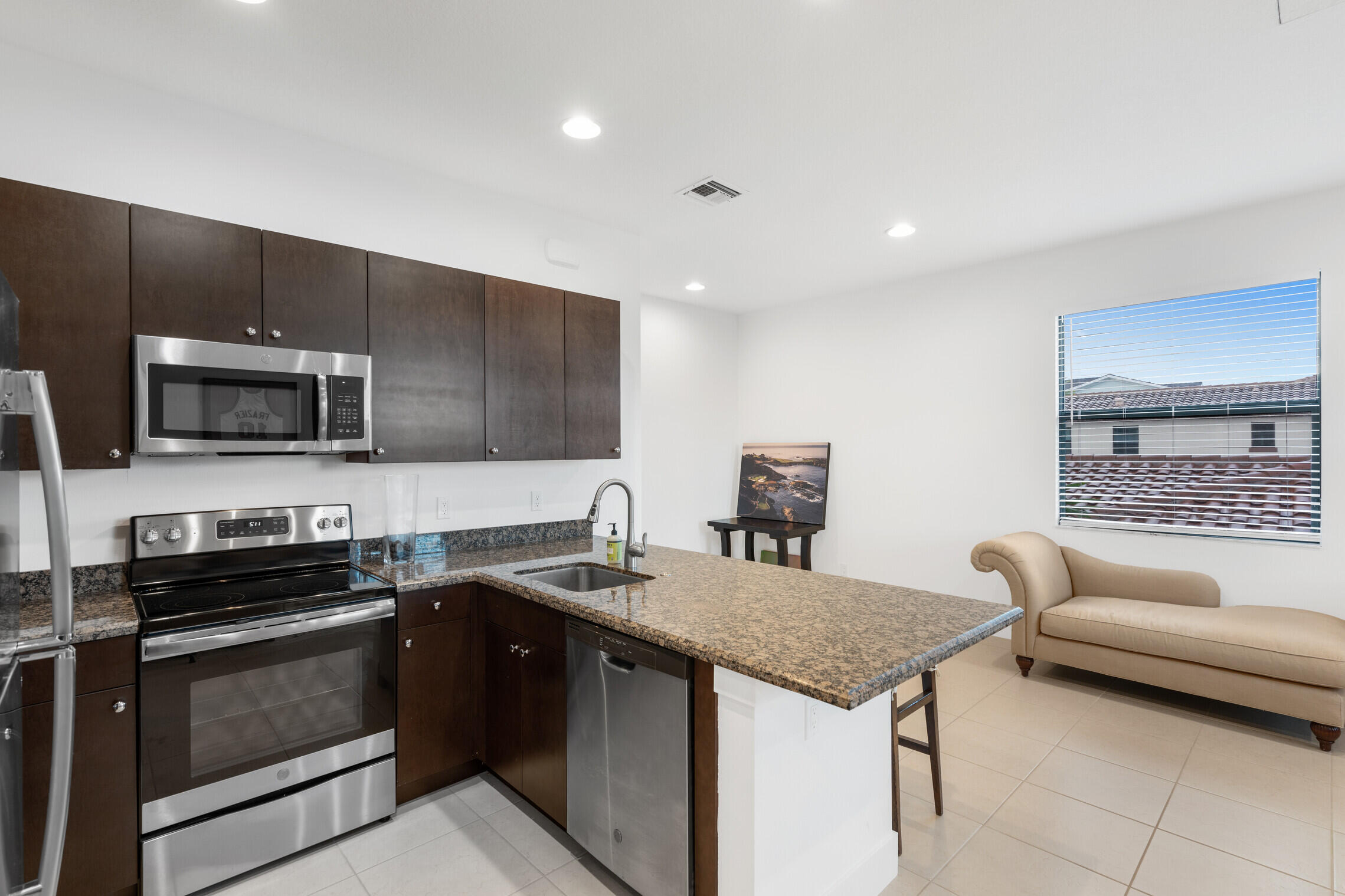 4084 Faraday Way Palm Beach Gardens, FL 33418 - Photo 35 of 43 a kitchen with a stove a sink and a microwave