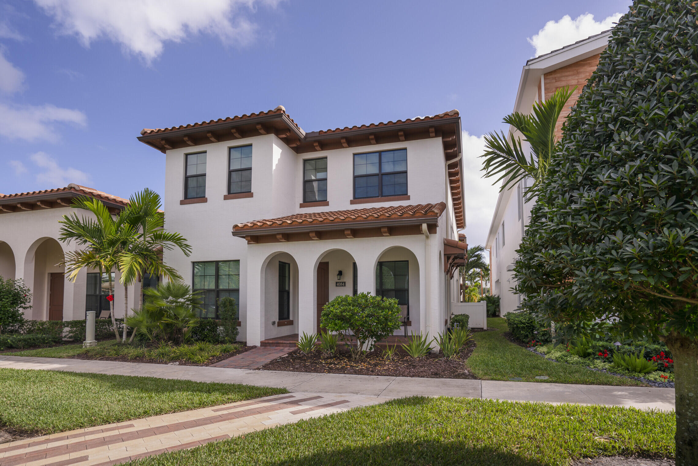 4084 Faraday Way Palm Beach Gardens, FL 33418 - Photo 7 of 43 a front view of a house with a yard and potted plants