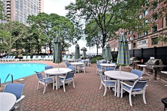 a view of a patio with a dining table and chairs with a small yard