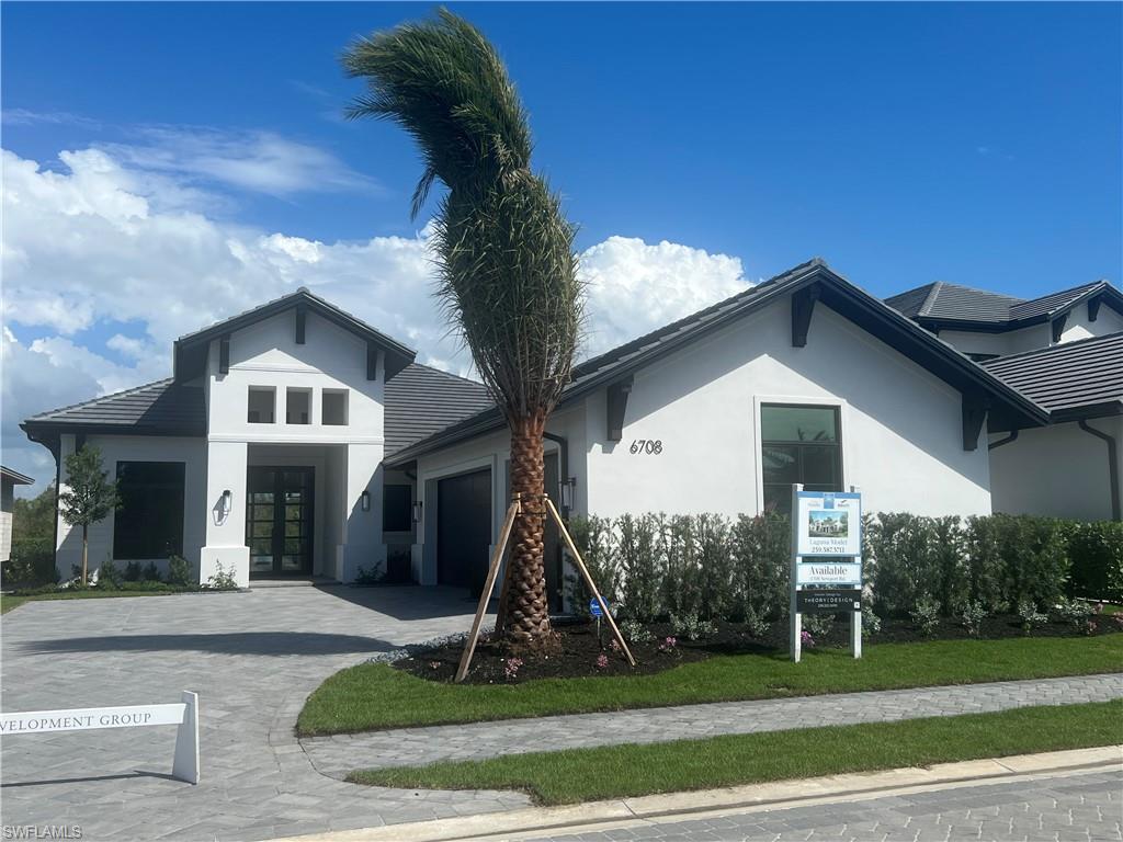 View of front of property with an attached garage, stucco siding, french doors, and decorative driveway