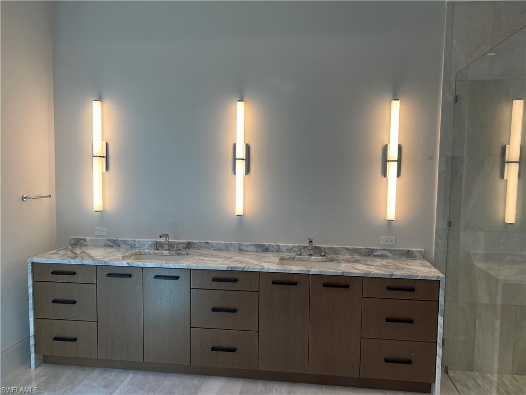 6708 Newport Road Naples, FL 34109 - Photo 12 of 48 Full bathroom with double vanity and a shower stall
