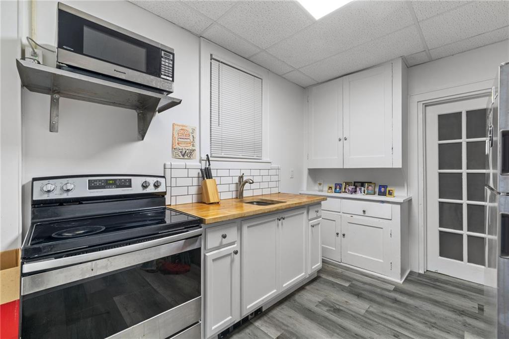 2923-2925 Brownsville Road Pittsburgh, PA 15227 - Photo 24 of 38 a kitchen with a stove cabinets and wooden floor