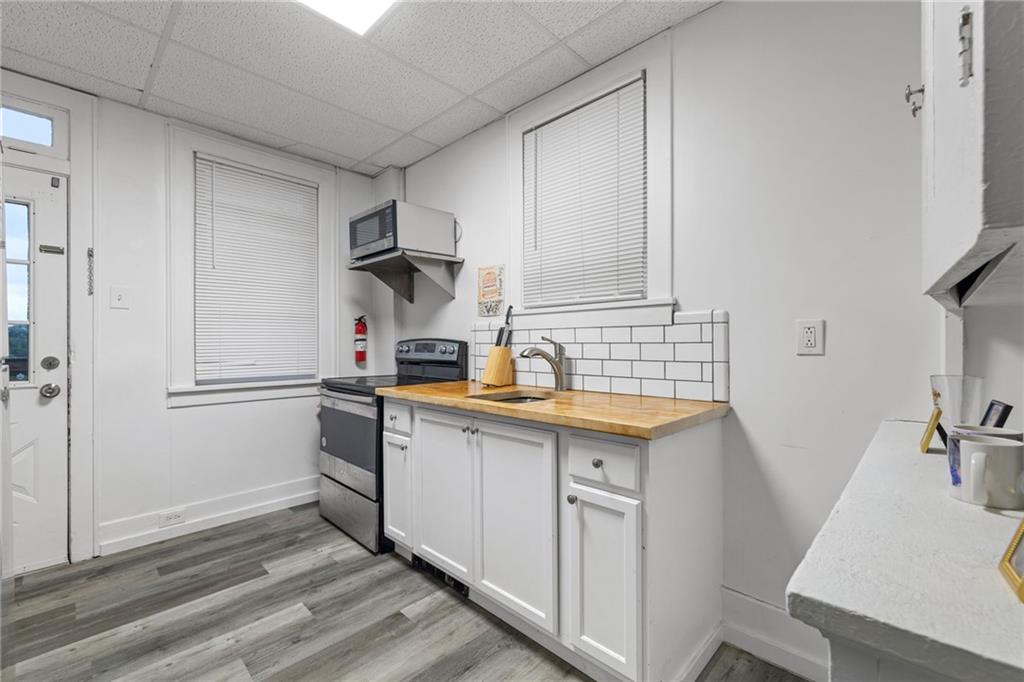 2923-2925 Brownsville Road Pittsburgh, PA 15227 - Photo 25 of 38 a kitchen with granite countertop a sink stove and cabinets