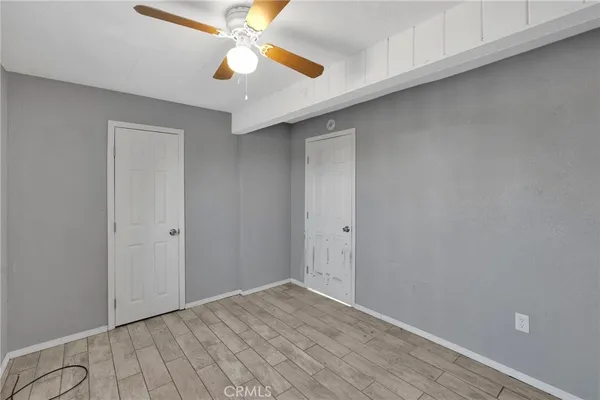 a view of an empty room and chandelier fan
