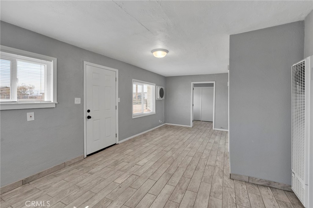 33454 Hampton Way Daggett, CA 92327 - Photo 3 of 17 a view of an empty room with wooden floor and a window