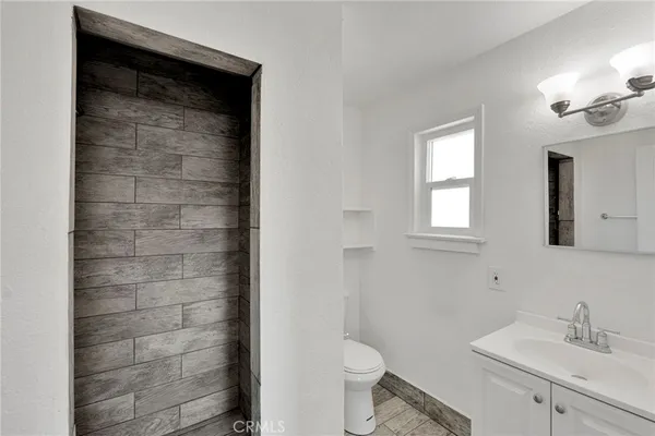 a bathroom with a sink a toilet and shower