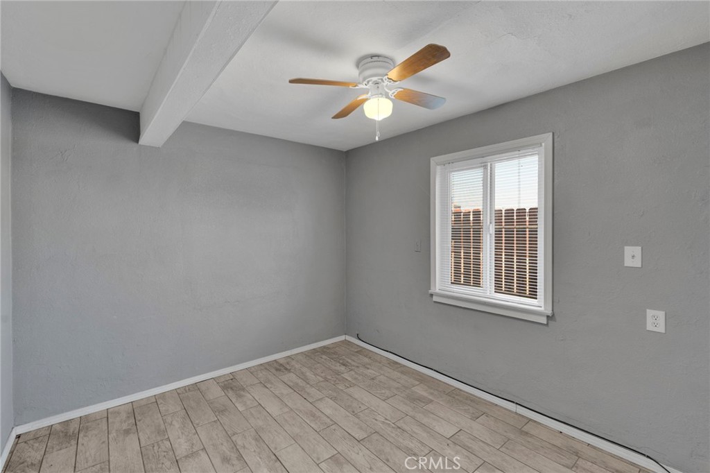 33454 Hampton Way Daggett, CA 92327 - Photo 10 of 17 an empty room with wooden floor fan and windows