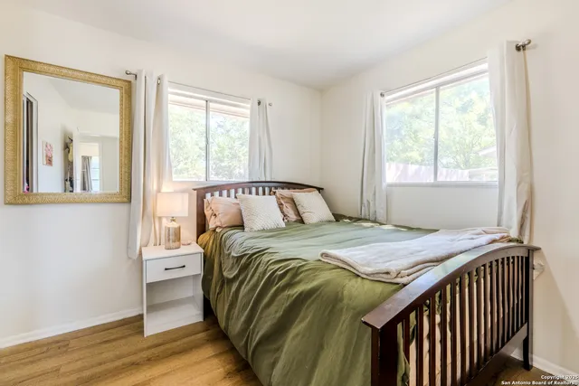 a bedroom with a bed and wooden floor