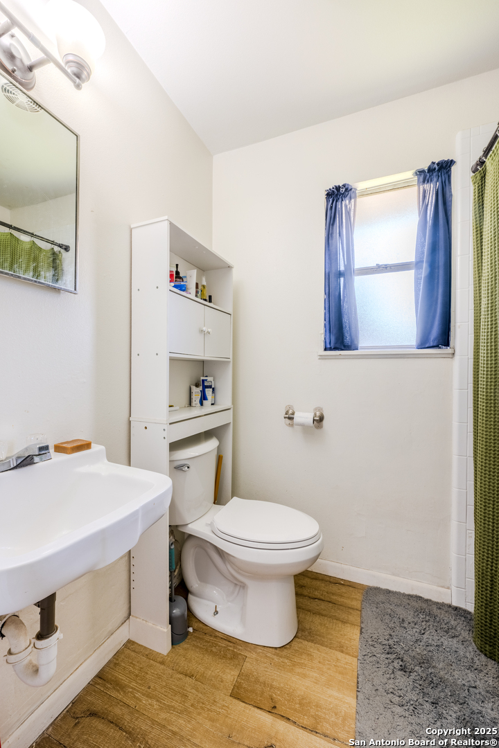 112 East Knippa Street Uvalde, TX 78801 - Photo 5 of 14 a bathroom with a sink toilet and a mirror