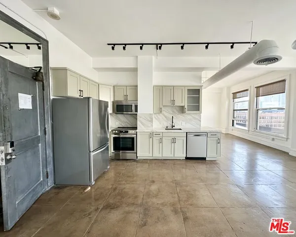 a large kitchen with cabinets and stainless steel appliances