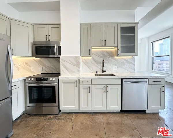 a kitchen with stainless steel appliances granite countertop a stove a sink and a microwave