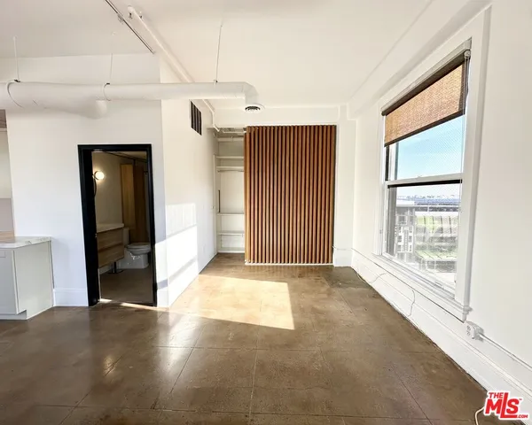 a view of an empty room with glass door and a window