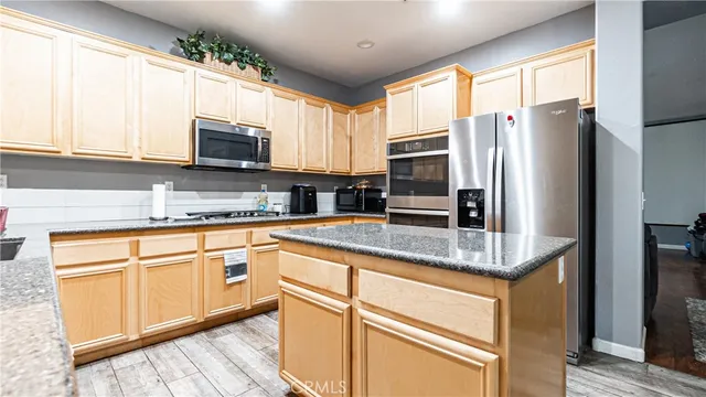 a kitchen with stainless steel appliances granite countertop a refrigerator and a sink